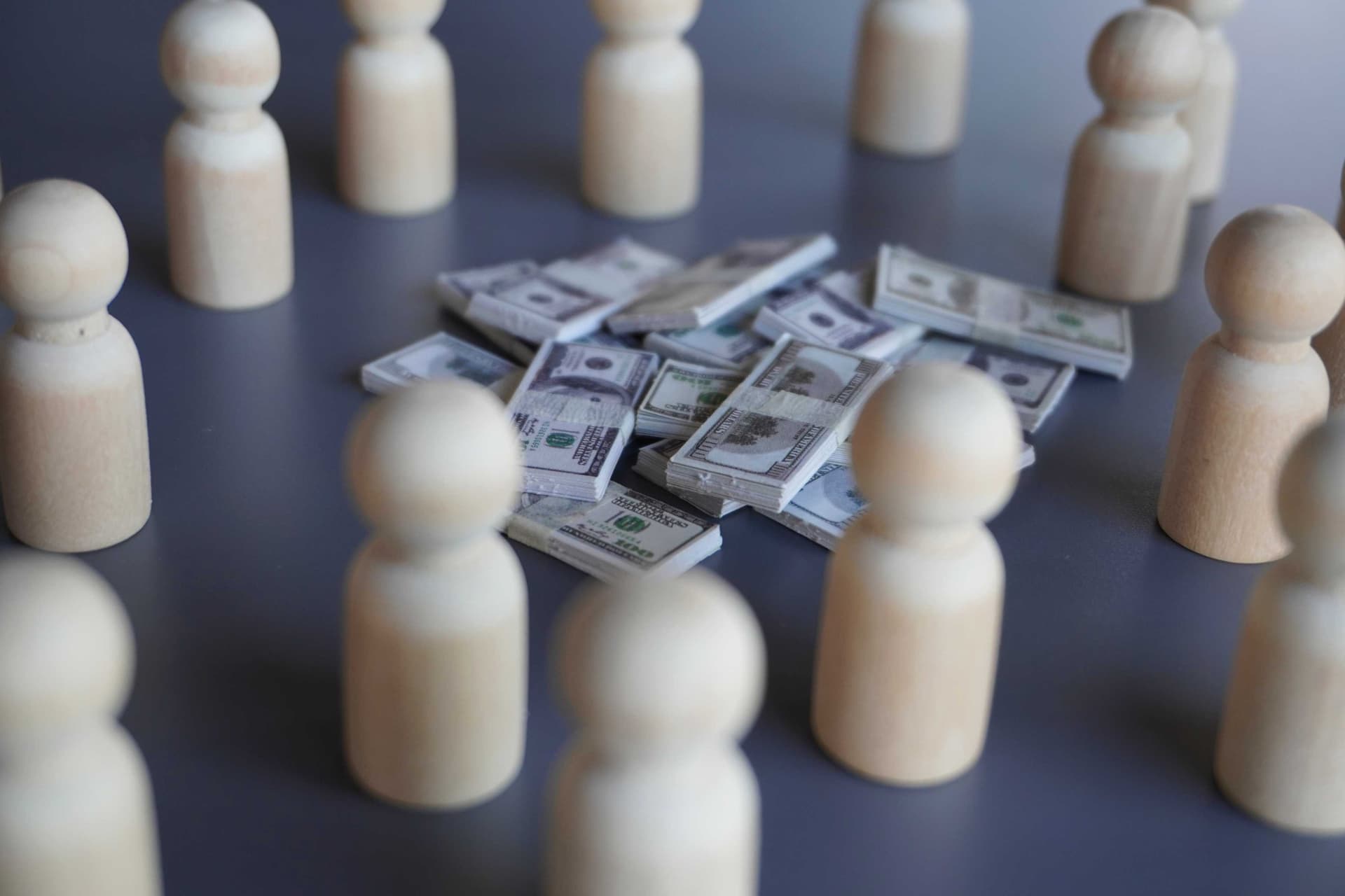 Wooden figures surrounding stacks of money, illustrating the hidden financial impact of poor Microsoft Dynamics 365 data quality with Dynamics Monk.